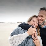 Dating after 40 symbolized by a man who strolls happily with his date at the beach