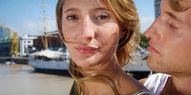 A women looking slightly away from a guy that wants to hug her.