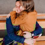 Man sitting on a bench with a woman on his lap as a symbol of how long-distance relationships can work.