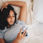 a girl laying in bed, dealing with how to get over a breakup