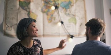 Man and woman sitting together at the harbor looking at each other as a symbol of how to get a boyfriend
