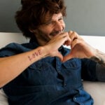 Man holding a heart with two hands in front of his chest as a symbol for long-distance relationships