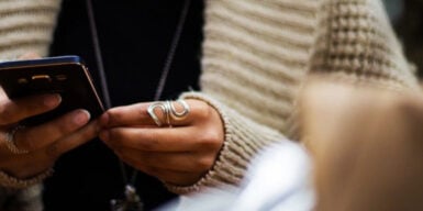 Man and woman both sitting on cell phone as symbol for dating red flags