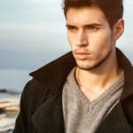 Man by the sea looks thoughtful and considers: "Why am I single?"