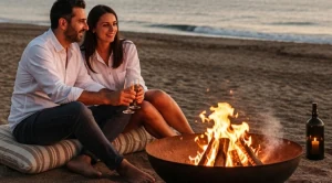 A couple sitting around a bonfire at the beach.