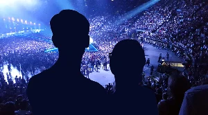A couple looking at a stage and enjoying live music.