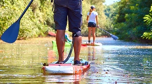A couple paddleboarding on a lake.