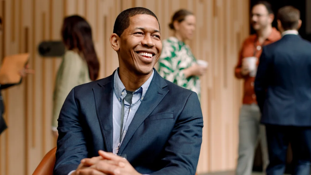 A man in a suit talking in a dating situation to another person.