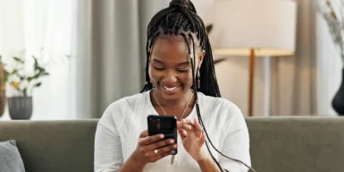 Women looking on a phone smiling learn how to ask someone out over text