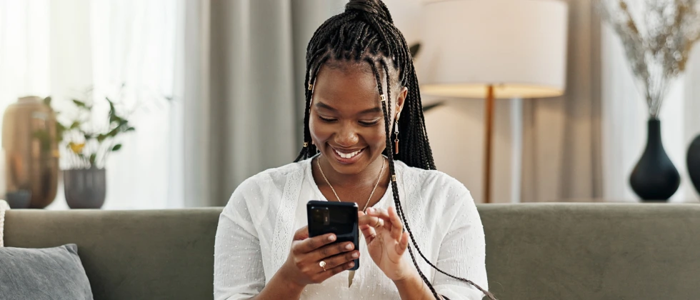 Women looking on a phone smiling learn how to ask someone out over text