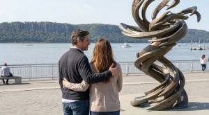 A couple looking at the yonkers whirlwind at the waterfront.