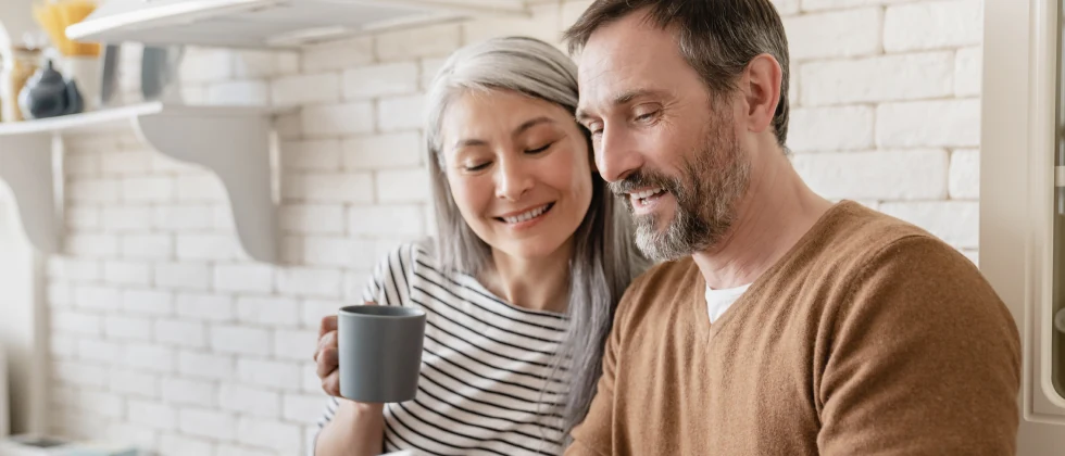 A couple in the kitchen having a conversation.